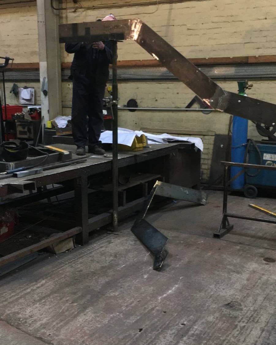 Close-up steel fabrication and welding on a workshop bench in London