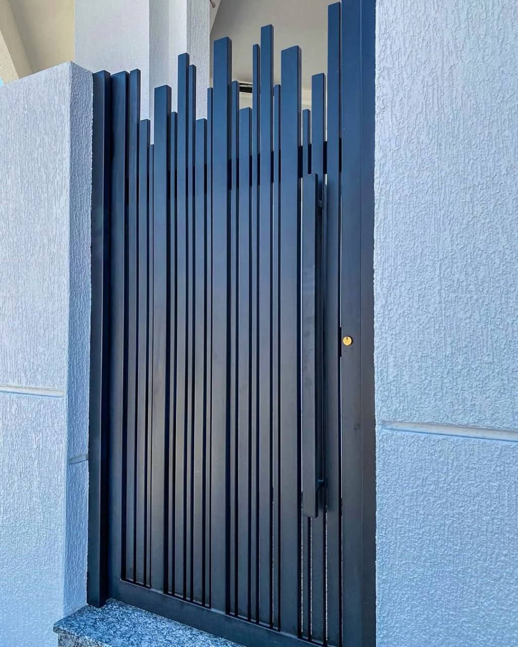 Close-up detail of timber-look slat finish and gate hardware against a rendered wall