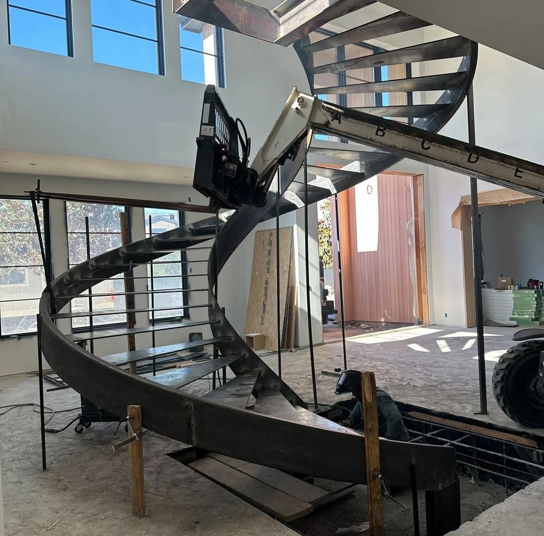 curved steel stringer sections being lifted into place during on-site installation