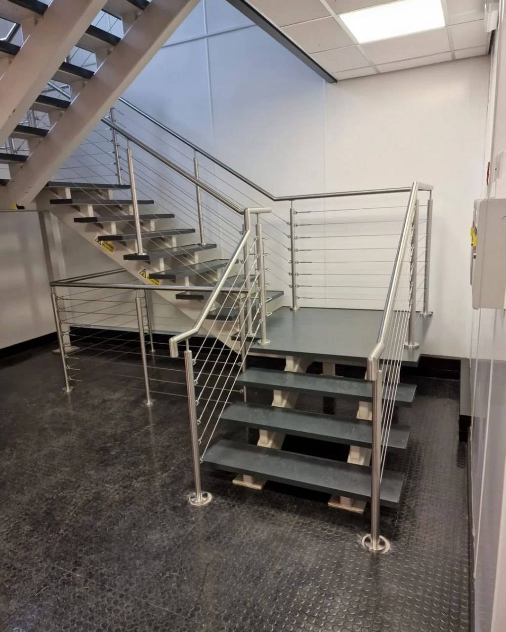 Floating staircase with open timber treads and stainless steel cable balustrade