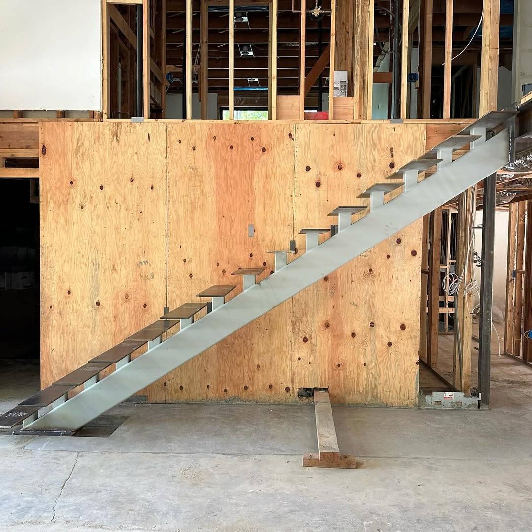 On-site installation and alignment of architectural steel staircase in progress